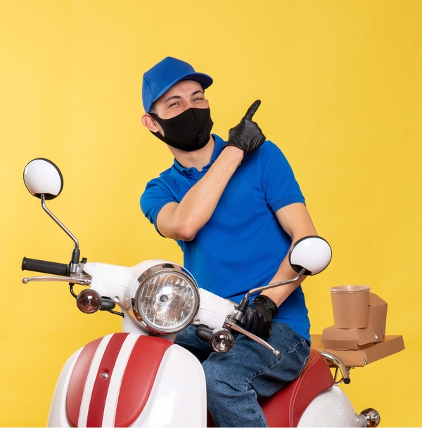Imagen de un mensajero en una moto señalando con el dedo índice.